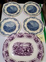 Four blue Grindley English ironstone plates with scalloped edges and detailed river scenes, arranged in a square.