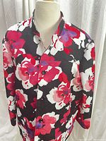 Front view of Alfred Dunner women's floral print cotton blazer with pink, red, purple, white flowers on black background. Collarless open front and long sleeves.