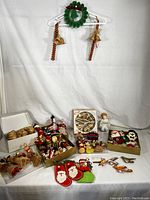 Full view of rustic traditional Russian Christmas ornaments including wreath, candles, burlap angels, Santa figures, and assorted small folk ornaments.