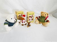 Photo showing five teddy bears including two boxed 'Teddy by Me' bears along with three other plush bears.