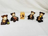 Four vintage Goebel bear figurines arranged standing showing front details and color
