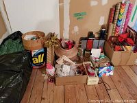 Full lot displaying a faux Christmas tree bag, storage tins, gift bags, and assorted wrapping supplies.