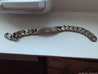 Full length view of the sterling silver ID bracelet showing the curb chain and the blank ID plate.