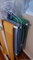 Three wool blankets hanging on a rack: mustard yellow, grey, and green color wool blankets.