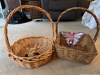 Photo showing two large wicker baskets on a carpeted floor; one round with small brown dog Beanie Baby inside, one rectangular with pink and purple butterfly Beanie Baby inside.