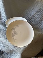 Two china plates stacked showing the floral design on the top plate.