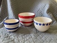 Photo of three ceramic bowls with Fourth of July themed designs: blue stripes on white, red stripes on white, and blue stars on white.