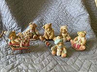 Seven Cherish Teddies holiday themed figurines arranged on quilted surface showing details and variety