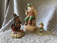 Photo of three Irish-themed figurines on a quilted gray backdrop