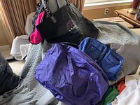 Four bags displayed together including two La Gear bags and two non-branded duffel bags of varying sizes and colors.