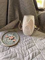 Light and Lyford suncatcher window hanger displayed together on a quilted cloth, showing the light with frosted wing motif and suncatcher with floral painting.