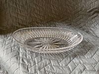 Side angle photo showing the profile and depth of the crystal oval dish with starburst design.