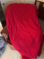 Red down throw blanket placed over chair