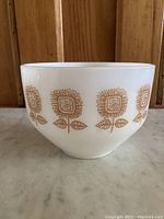Front view of the vintage Federal Glass milk glass bowl showing the full sunflower pattern around the side.