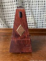 Front view of Wittner wooden mechanical metronome showing wood grain and diamond-shaped metal plate.