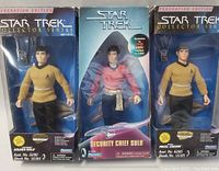 Front view of three Star Trek action figures in original packaging. Pavel Chekov and Hikaru Sulu in yellow uniforms, Security Chief Sulu in red uniform with silver sash.
