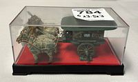Miniature horse and buggy sculpture inside a clear plastic display case with black base and red interior base. The horses are harnessed to the buggy, which has a covered cabin.