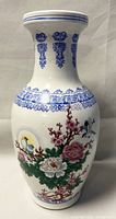 Full view of the vase showing the shape, hand-painted floral and bird design, and blue decorative patterns on the neck and rim.