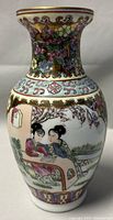 Frontal view of Chinese pottery vase showing painted scene of two women sitting at a table under a blossoming tree, with floral patterns and gold accents