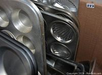 Close-up photo showing muffin pans, tart pans, and loaf pan in box.
