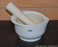 Mortar with pestle resting inside, showing side profile and mouth opening