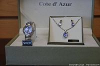Photo of the Cote d' Azur gift set showing the watch, necklace, and matching earrings inside branded box with price tag on watch.