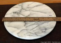 Top view of the round marble turntable showing veining and approximate measurement with a ruler.