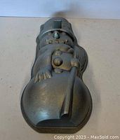 Top view of metal snowman-shaped baking pan showing front of figure with hat and details.