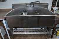 Front view of stainless steel triple sink with legs and wire under-shelf