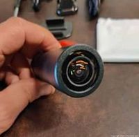 Close-up of the cylindrical action camera lens held in hand.