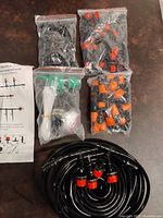 Full overview of irrigation system parts on table including tubing, connector bags, misting nozzles, and instruction sheet.