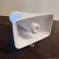 Front angle view of the white plastic electronic siren horn showing the horn opening and wires.