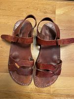 Top view of camel leather sandals showing three straps and stitching detail.