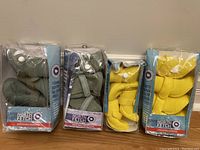 Four pairs of North Fetch dog boots in original packaging, two army green and two sunshine yellow.