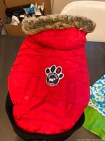Red Canada Pooch dog winter jacket with faux fur lined hood, Canada Pooch paw print logo patch visible
