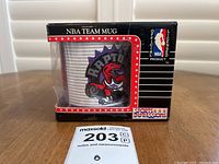Front view of the Toronto Raptors NBA collectors mug in its original box showing the logo and NBA licensed product markings.