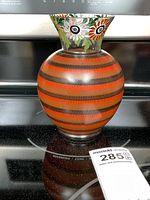 Front view of Art Deco Czech glass vase showing rounded body with orange and black stripes and stylized floral patterns on flared rim