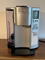 Front view of the silver Cuisinart single cup coffee maker showing the water tank and control panel