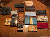 Full view of the lot showing all wallets and the crossbody bag laid out on a wooden table