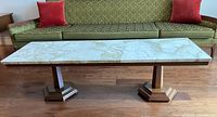 Front view of the mid-century modern coffee table with marble top and wooden base showing the long rectangular shape and the beige veining on the marble surface.