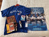 Full lot showing Blue Jays T-shirt, signed poster, baseball, bobblehead, and World Series items.