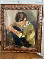 Full view of the framed oil painting showing a boy seated with his arms around his knees, with visible signature in the lower right corner.