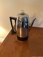 Full view of vintage Sunbeam electric coffee maker in stainless steel with black handle and base