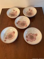 Five Denby Gypsy pattern cereal bowls arranged on a wooden surface showing the floral design.