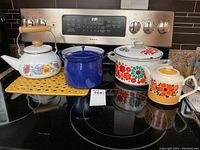Full lot displayed on stove top showing all enamelware pieces and Sadler teapot.