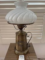 Front view of complete vintage metal table lamp with white ribbed glass shade.