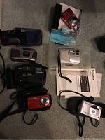 Seven film and digital cameras including Pentax, Kodak Star Focus Free, Advantix 4800ix, Fujifilm 102ix, and five AX500 models.