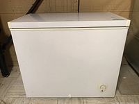 Front view of white Frigidaire chest freezer showing front panel with round control knob.