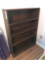 Full view of the wood veneer shelving unit showing the front and side, with three fixed shelves inside.