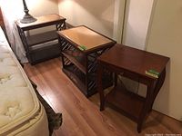 Three wood veneer side tables arranged side by side. Two tables have fretwork sides and mirrored tops with visible scratches and damage; the third has a drawer and curved legs.